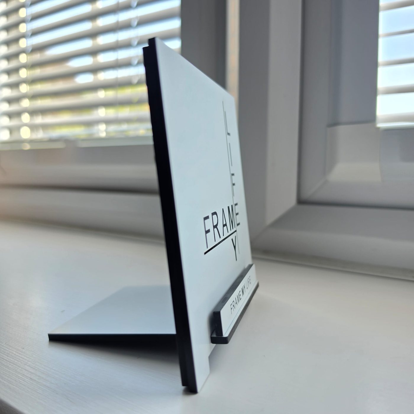 The display stand seen from the side, showing the angled easel back and the channel the keepsake sits in